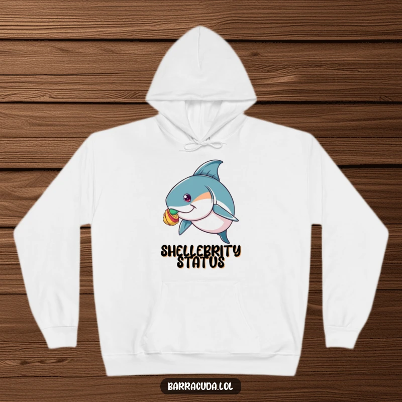 Funny hoodie depicting a barracuda with intense focus, attempting to balance a delicate, colorful shell on its nose.